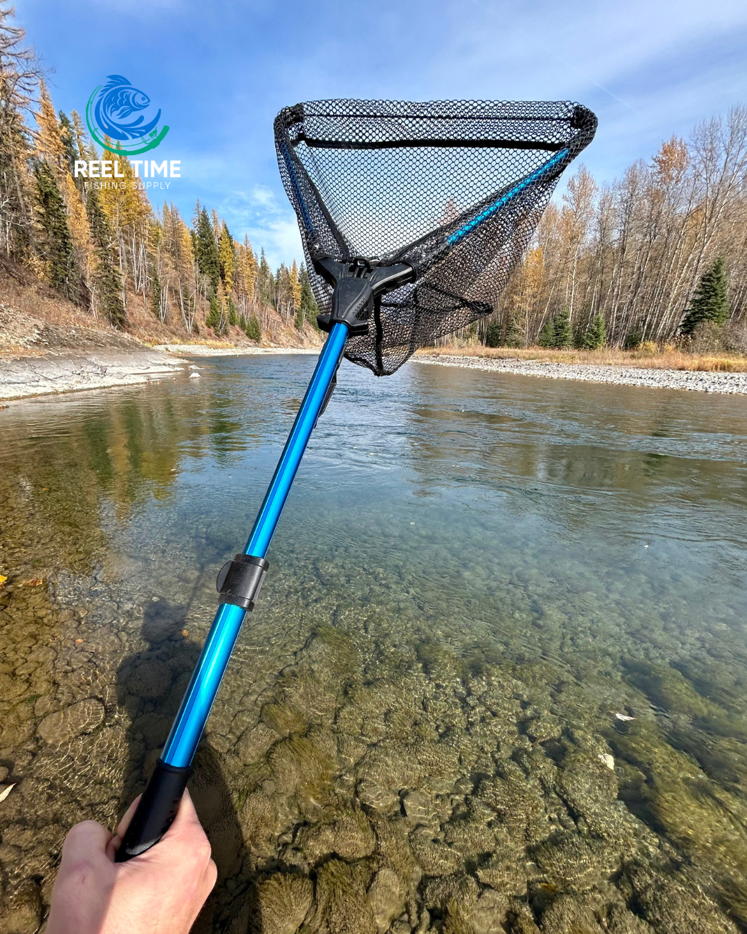 Angler holding a Collapsible Travel Landing Net by a river, showcasing its compact and lightweight design. Net is fully extended.