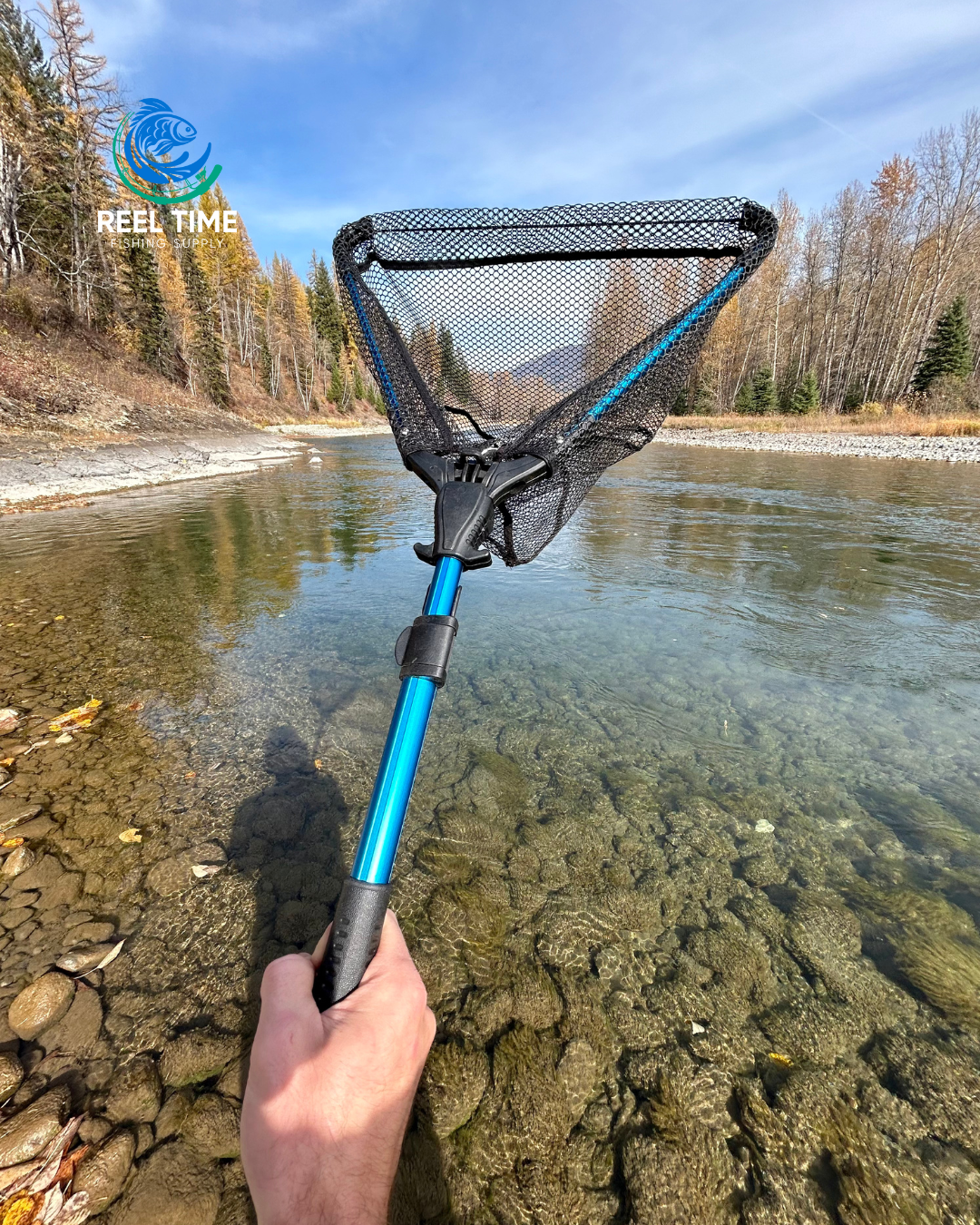 Angler holding a Collapsible Travel Landing Net by a river, showcasing its compact and lightweight design. Net is half extended.