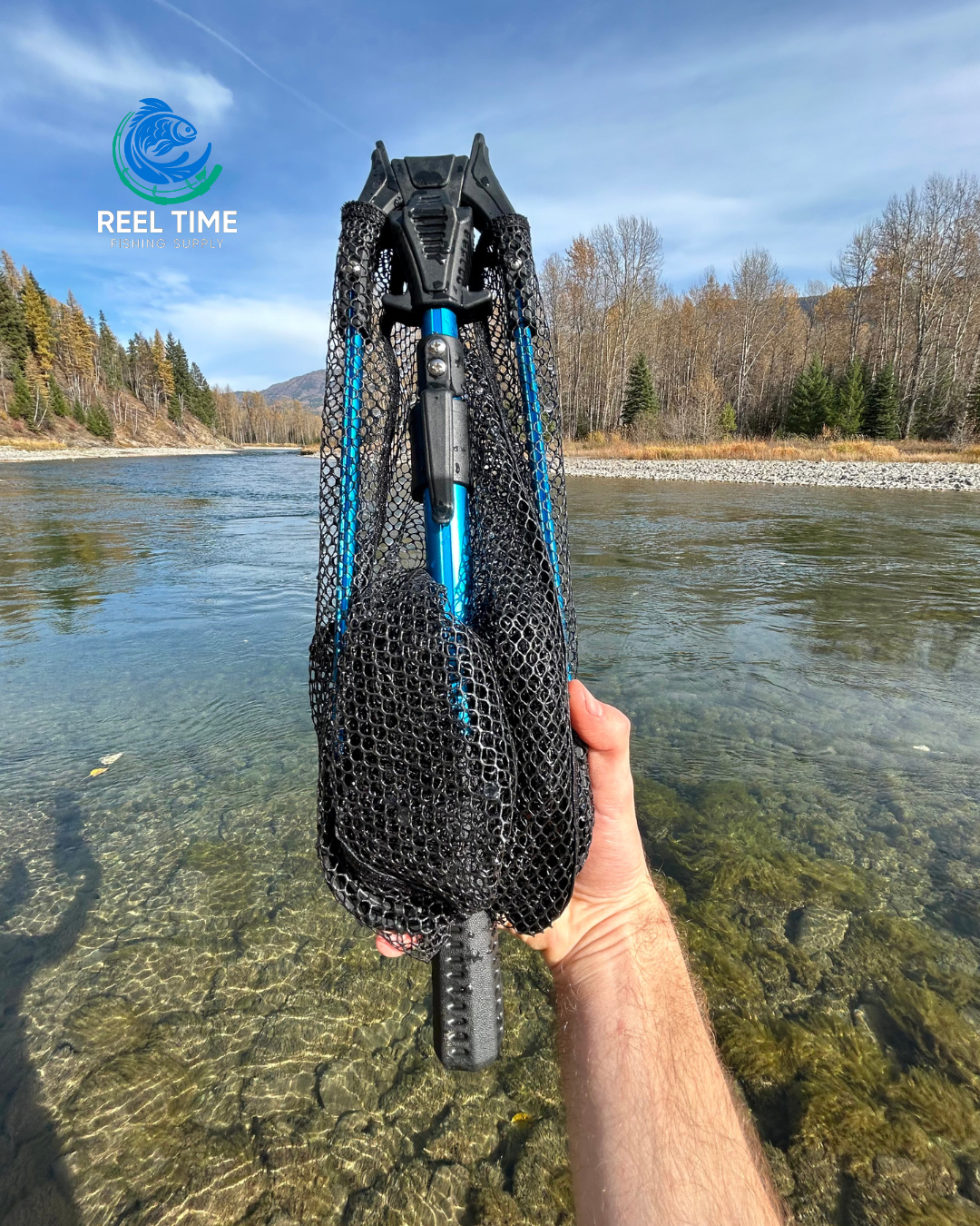 Angler holding a Collapsible Travel Landing Net by a river, showcasing its compact and lightweight design. The net is folded neatly into its compact form.