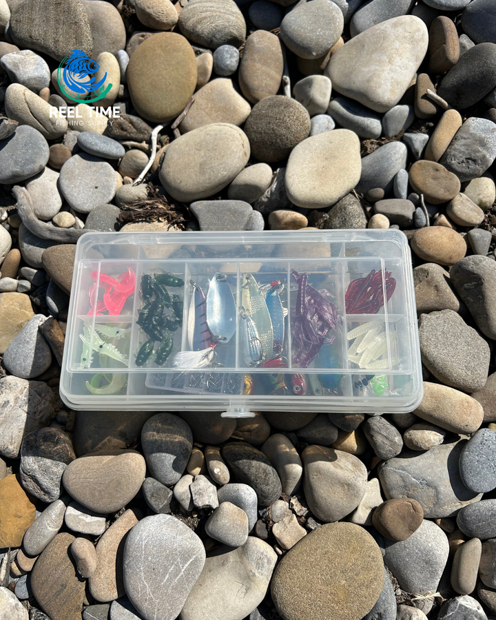 Compact tackle box sitting on river rocks with lid closed showcasing its compact and portable design.