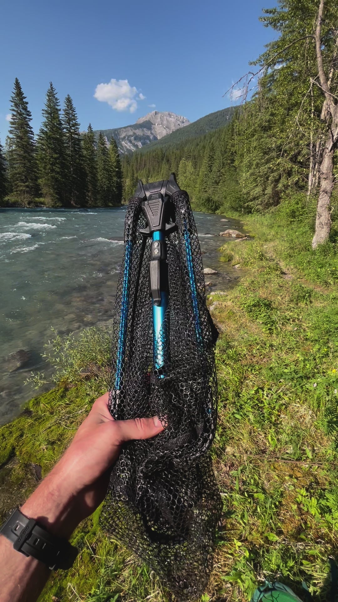 Angler demonstrating the functionality of the collapsible travel landing net. Portable and compact design, extends into a fun size landing net.